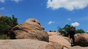 A person walking between red bolders