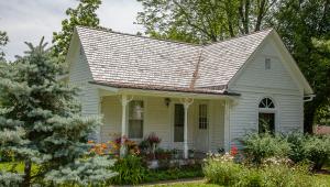 A small white house with flowers out front