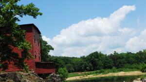Red mill by a body of water