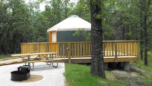 A tent on a wooden deck with a fire pit nearby