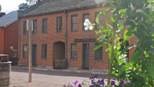 An old brick store with a "dry goods and hardware" sign