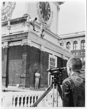 Black-and-white photo of a man photographing a building