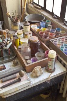 Painting supplies on a desk next to a window