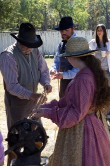 men in period attire demonstrate rope making