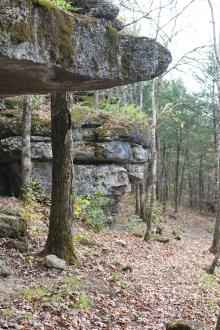 a hiking path underneath a rocky cliff