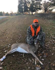 A hunter posing with a deer