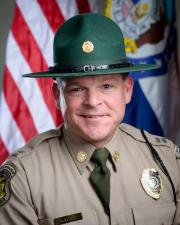 Ranger Clint Kincade standing in-front of a flag