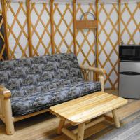 Futon and mini fridge and microwave inside the yurt