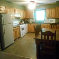 kitchen with refridgerater, stove and dining table and chairs