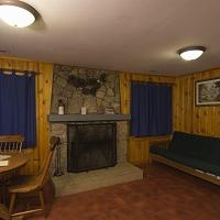 fireplace, dining table and futon inside a cabin