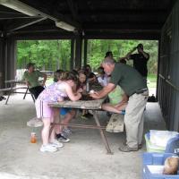 some kids looking at something that the naturalist is showing them