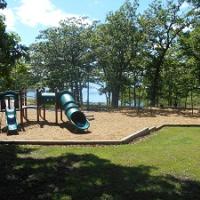 playgroudn equipment with two slides and a swing set